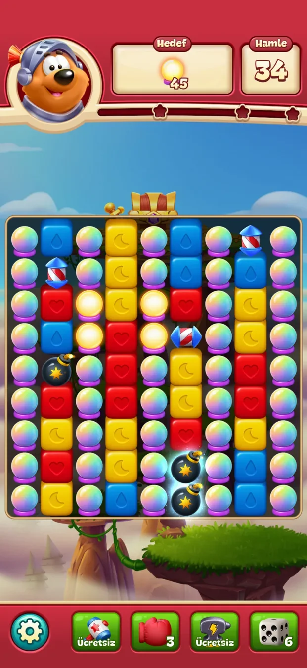 A Toon Blast level in progress with a row of booster options below the board